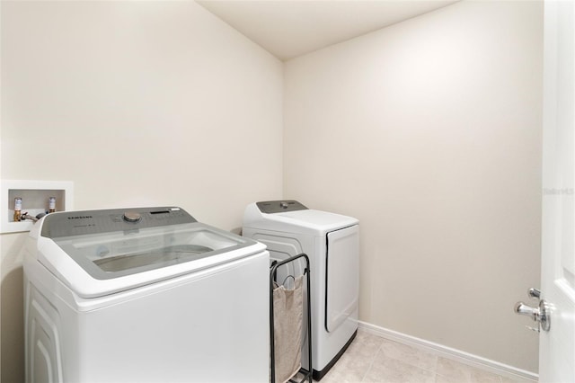 clothes washing area featuring washer and dryer and light tile patterned floors