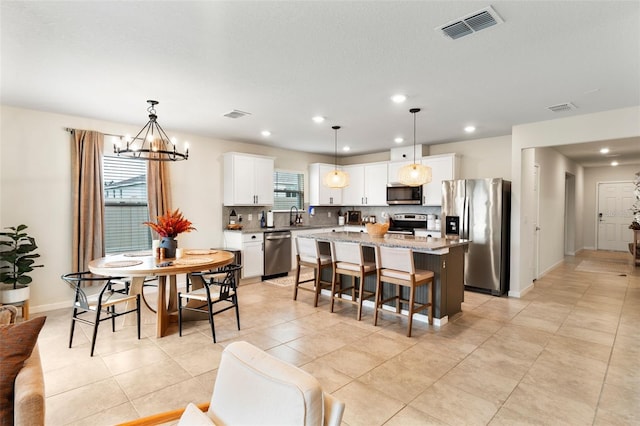 tiled dining room featuring an inviting chandelier, sink, and a wealth of natural light