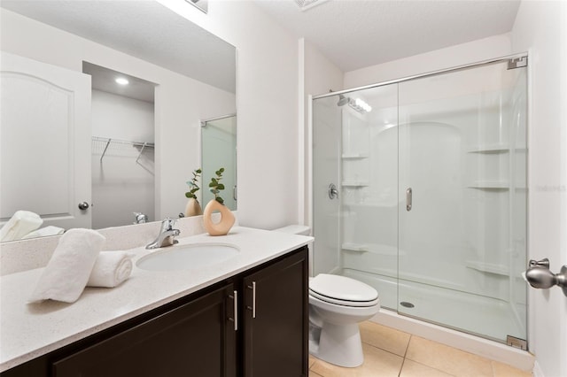 bathroom with toilet, a textured ceiling, an enclosed shower, tile patterned flooring, and vanity