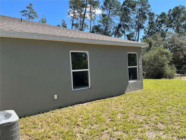 view of property exterior featuring central AC unit and a lawn