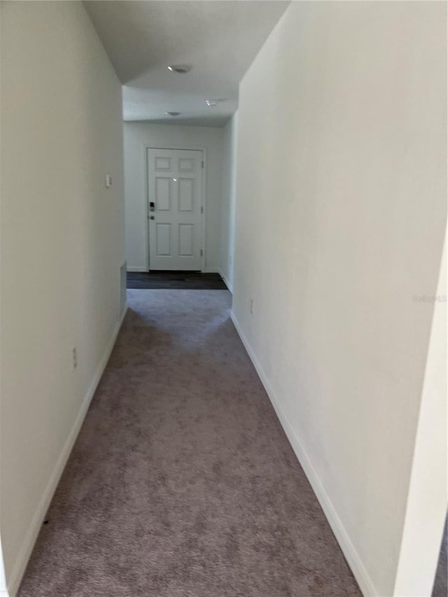 hallway featuring dark carpet