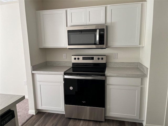 kitchen featuring dark wood-type flooring, appliances with stainless steel finishes, and white cabinets