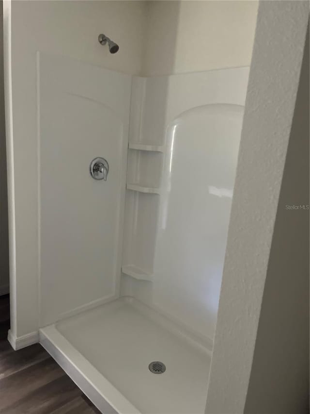 bathroom featuring wood-type flooring and a shower