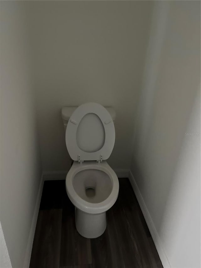 bathroom with toilet and hardwood / wood-style floors