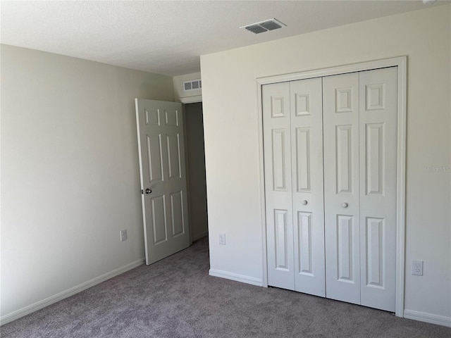 unfurnished bedroom featuring a closet, carpet, and a textured ceiling