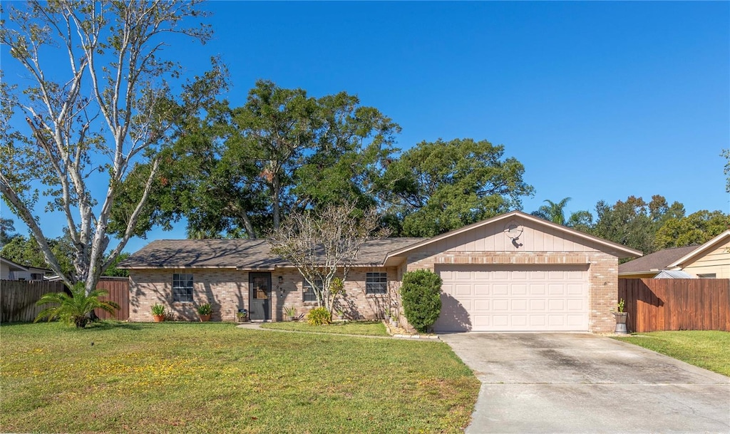 ranch-style home featuring a front lawn and a garage