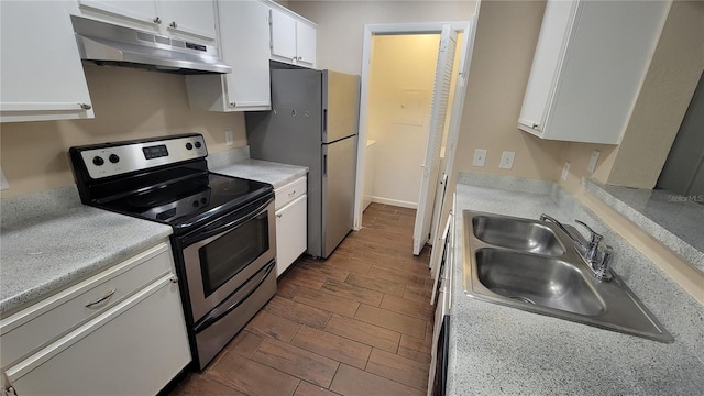 kitchen with under cabinet range hood, stainless steel appliances, light countertops, a sink, and white cabinetry