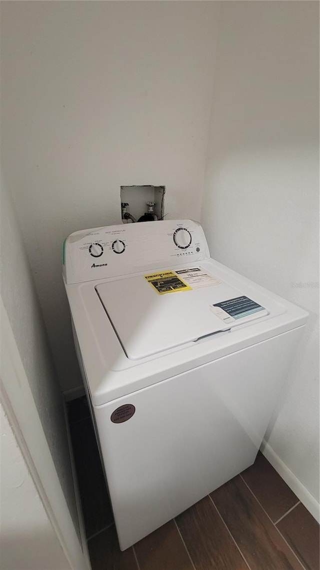 clothes washing area featuring dark hardwood / wood-style flooring and washer / clothes dryer