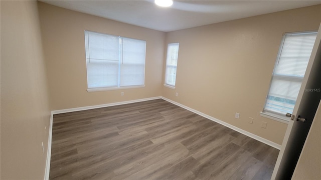 unfurnished room with hardwood / wood-style flooring