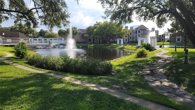 view of property's community featuring a water view and a yard