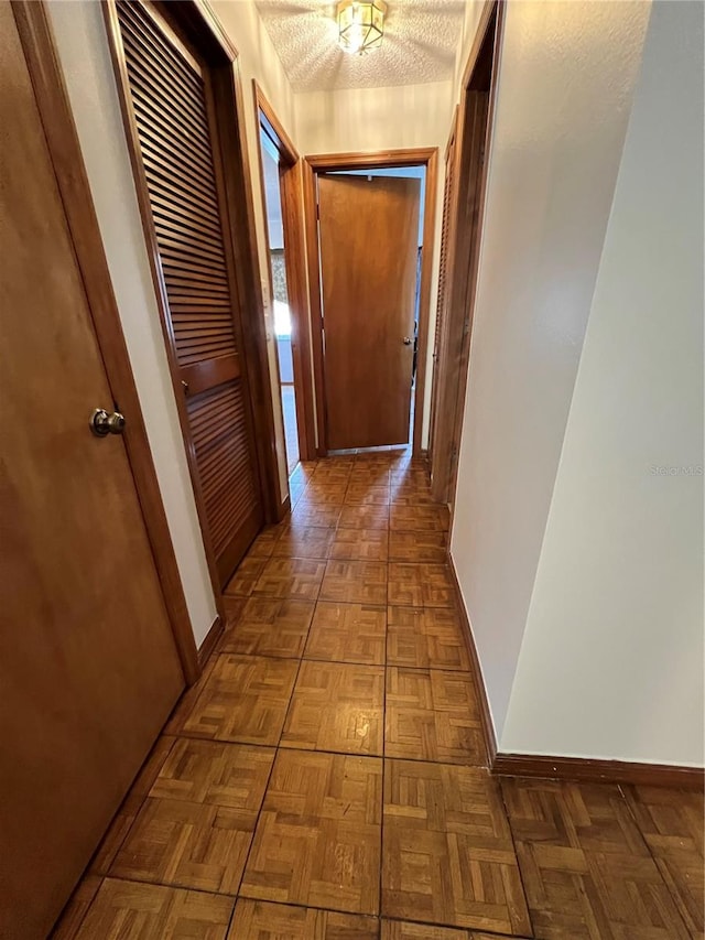 hall featuring dark parquet floors and a textured ceiling