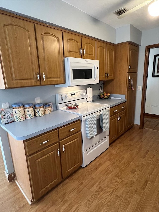 458 Windmeadows St, Altamonte Springs, FL 32701 - kitchen featuring white appliances, light wood finished floors, brown cabinets, and baseboards