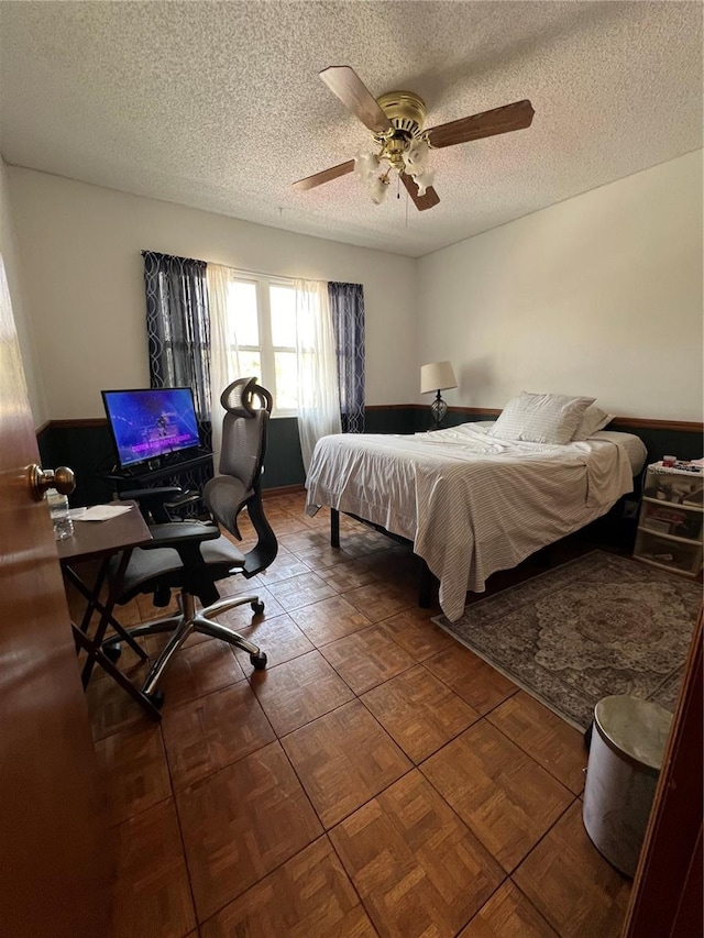 bedroom with a textured ceiling and ceiling fan