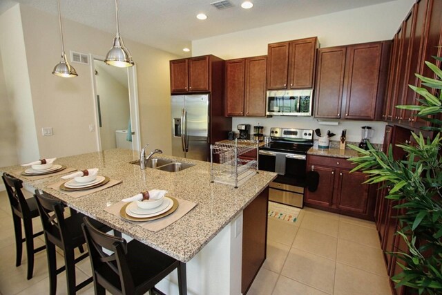 314 Captiva Dr, Davenport, FL 33896 - kitchen with appliances with stainless steel finishes, a sink, light stone counters, light tile patterned floors, and recessed lighting