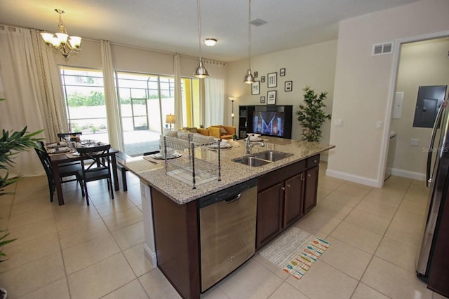 kitchen featuring light stone countertops, sink, an island with sink, stainless steel appliances, and pendant lighting