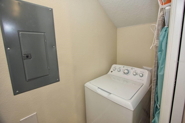 laundry area featuring washer / dryer, electric panel, and a textured ceiling