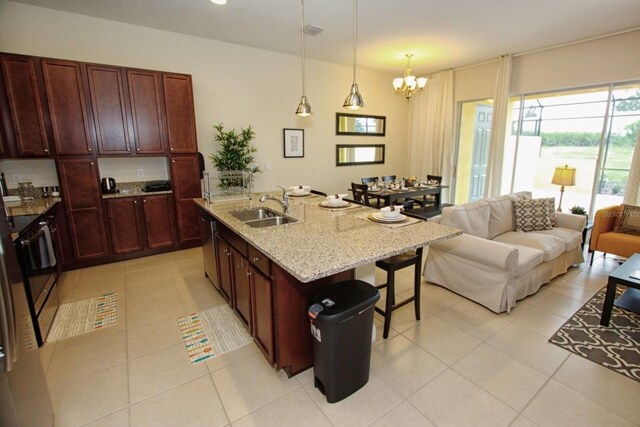 314 Captiva Dr, Davenport, FL 33896 - kitchen with a sink, a breakfast bar, light tile patterned flooring, a chandelier, and light stone countertops