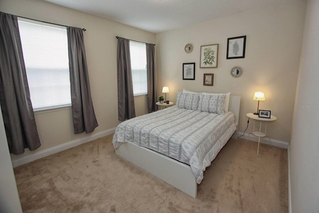 bedroom featuring multiple windows and light colored carpet