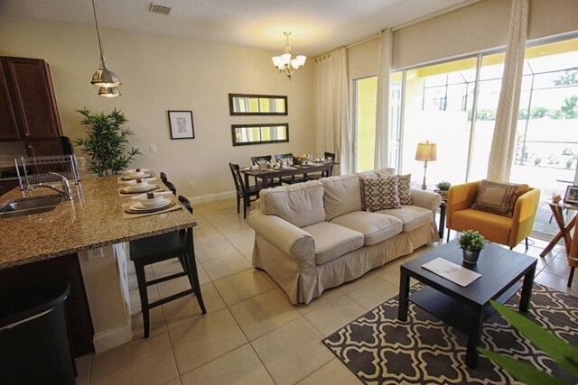 314 Captiva Dr, Davenport, FL 33896 - living room featuring plenty of natural light, a chandelier, light tile patterned flooring, and baseboards