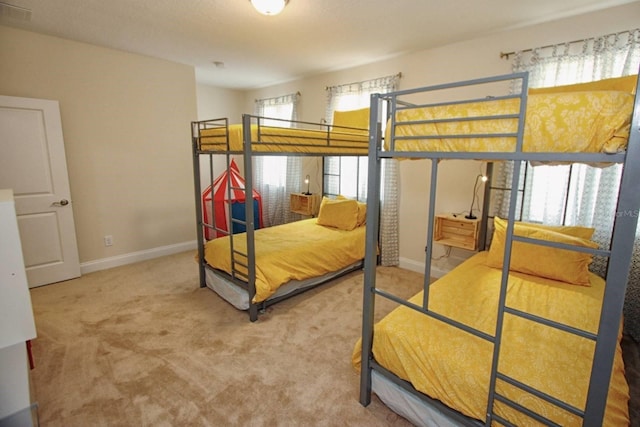 carpeted bedroom featuring multiple windows