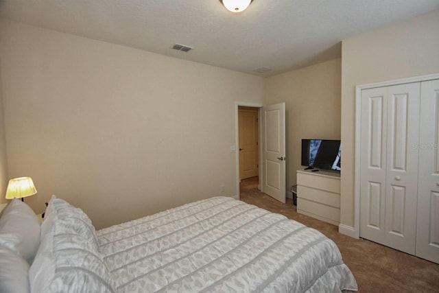 carpeted bedroom with a closet and a textured ceiling