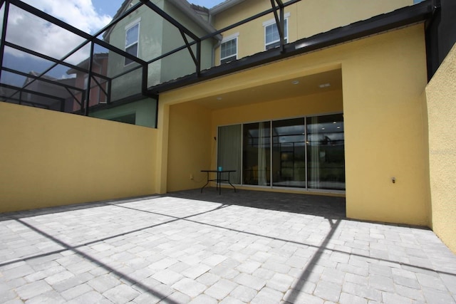 314 Captiva Dr, Davenport, FL 33896 - rear view of house featuring stucco siding, a patio, and glass enclosure