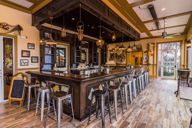 bar with beam ceiling, hardwood / wood-style floors, decorative light fixtures, and ceiling fan