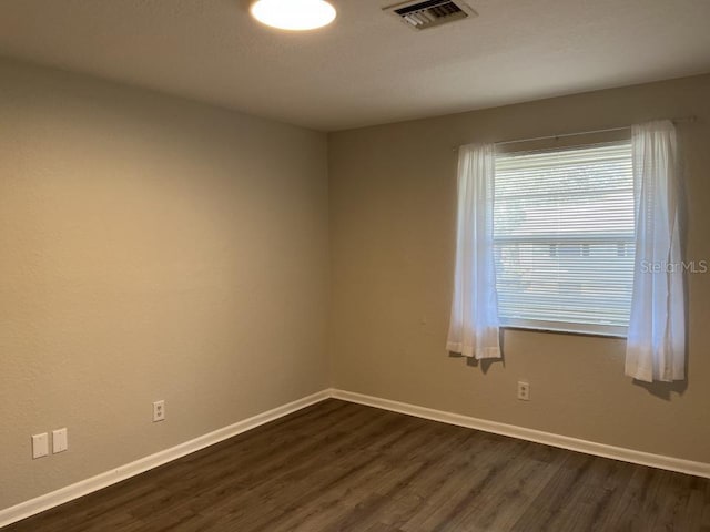 empty room with dark hardwood / wood-style flooring