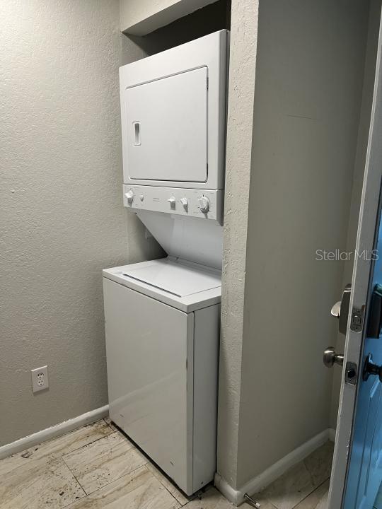 washroom featuring stacked washer / dryer