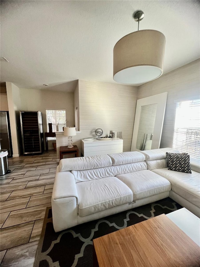 living room featuring light hardwood / wood-style floors, a textured ceiling, and a healthy amount of sunlight