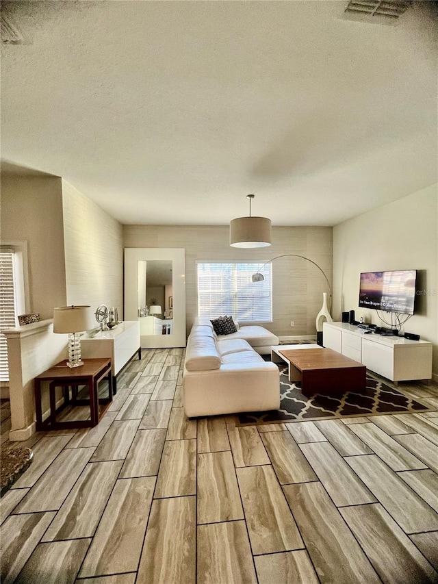 bedroom featuring a textured ceiling and light hardwood / wood-style flooring