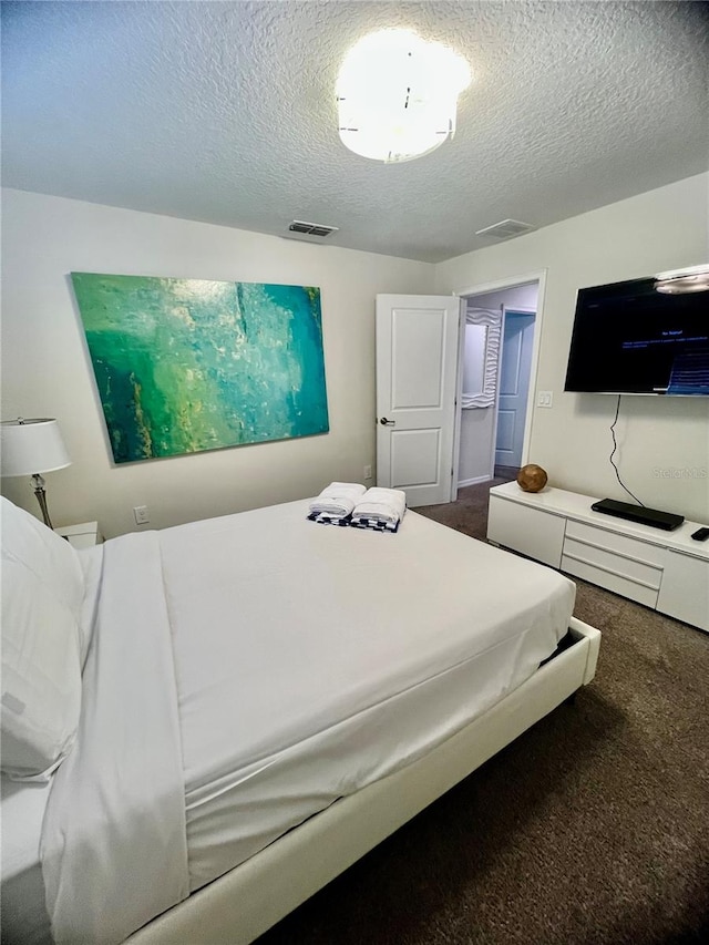 carpeted bedroom with a textured ceiling