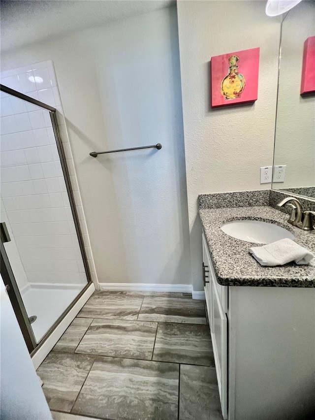 bathroom featuring vanity, a shower with shower door, and wood-type flooring