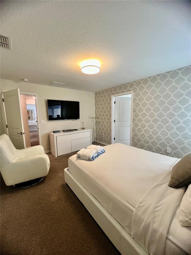 bedroom with a textured ceiling and carpet flooring