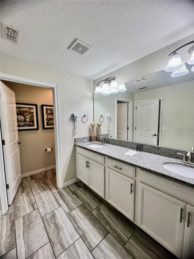 bathroom with vanity, a textured ceiling, and wood-type flooring