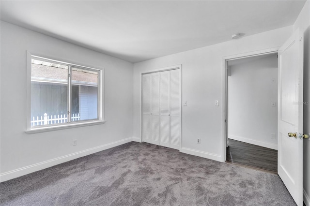 unfurnished bedroom featuring carpet floors, baseboards, and a closet