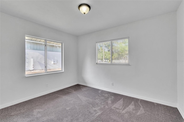 spare room featuring carpet floors and baseboards