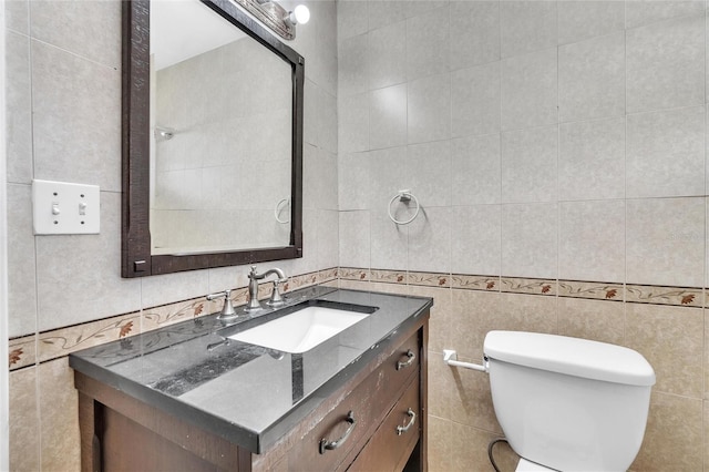 half bathroom with toilet, vanity, and tile walls