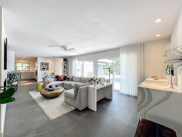 living room featuring ceiling fan and sink