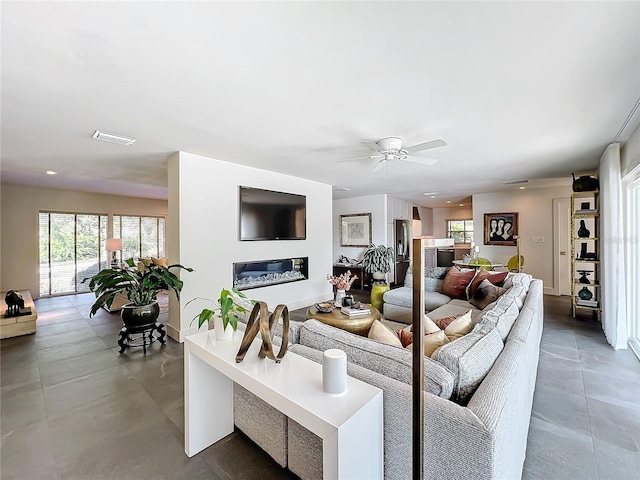 living room featuring concrete flooring and ceiling fan