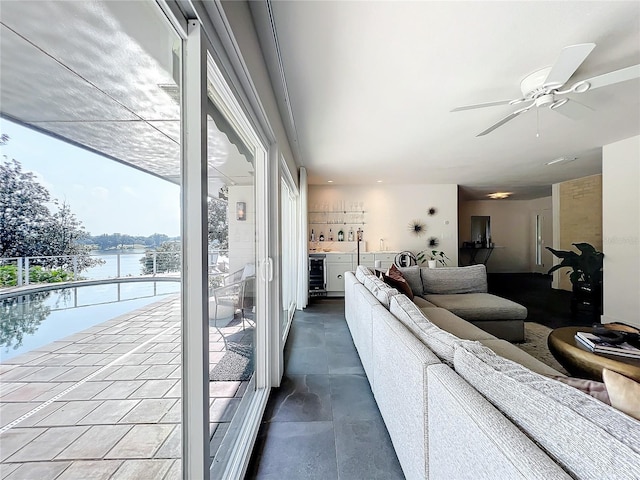 living room featuring a water view, wine cooler, and ceiling fan