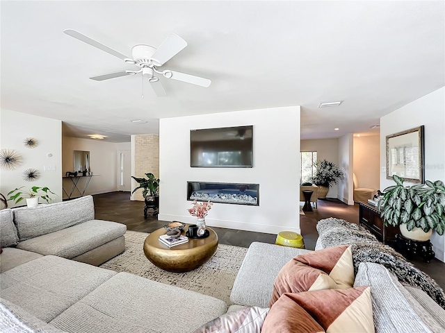 living room with ceiling fan and dark wood-type flooring