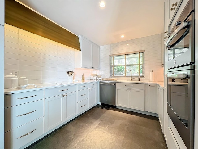 kitchen with appliances with stainless steel finishes, backsplash, sink, and white cabinets