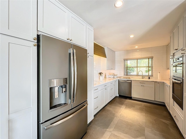 kitchen with decorative backsplash, appliances with stainless steel finishes, sink, and white cabinetry