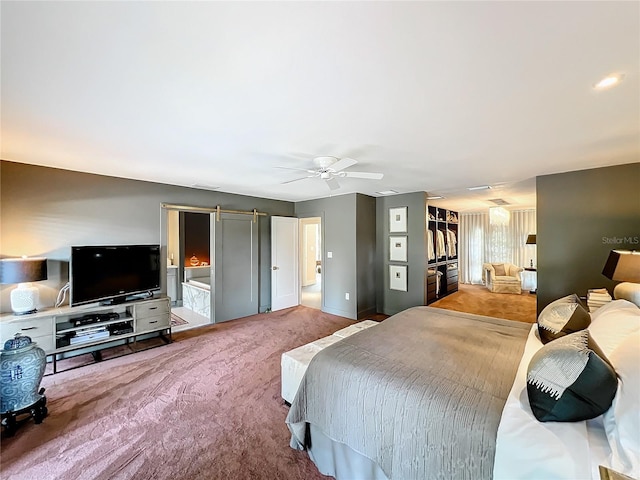 bedroom with a barn door, a closet, carpet flooring, and ceiling fan