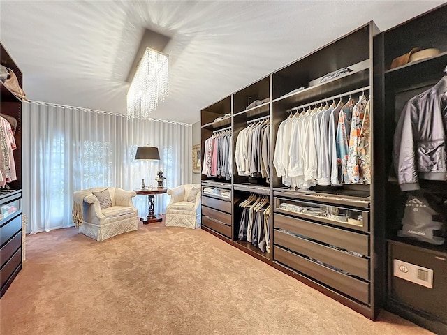 spacious closet featuring a chandelier and carpet flooring