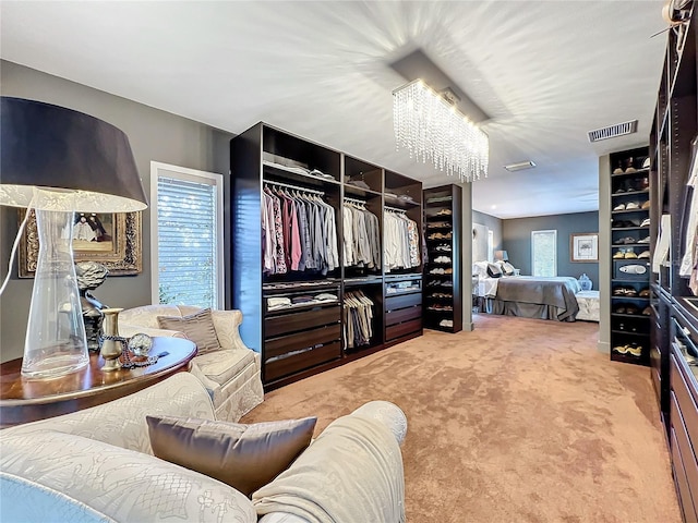 walk in closet featuring an inviting chandelier and carpet