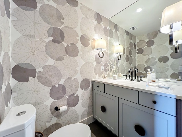 bathroom with tile walls, vanity, and toilet