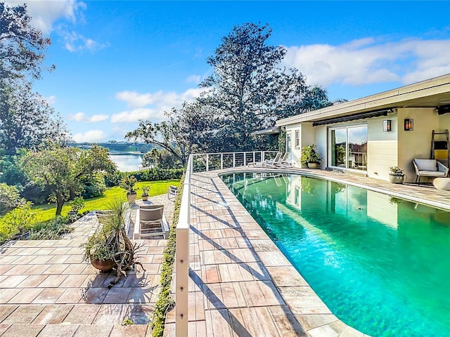 view of pool with a water view and a patio area