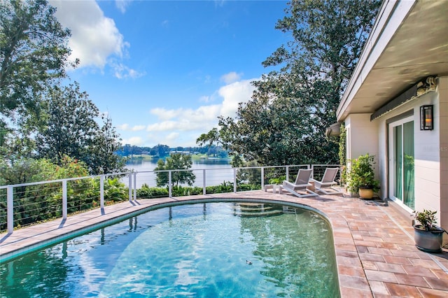 view of pool featuring a water view and a patio